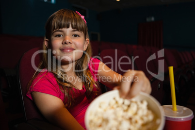 Portrait of girl showing popcorn container