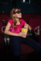 Smiling girl having popcorn while watching movie