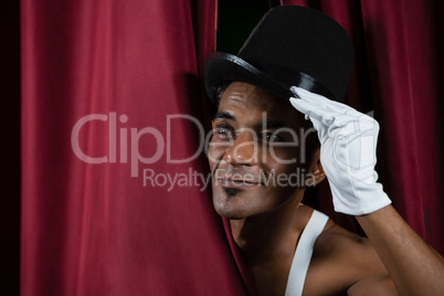 Ballet dancer peeking through a stage curtain