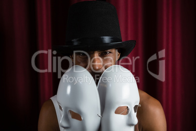 Artist holding two white mask