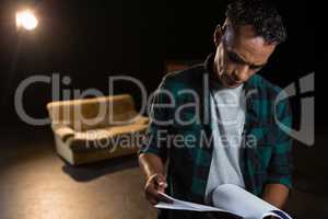 Actor reading their scripts on stage