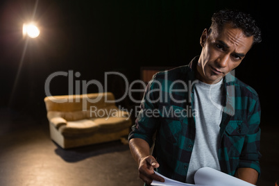 Actor holding his scripts on stage