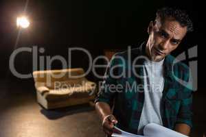 Actor holding his scripts on stage