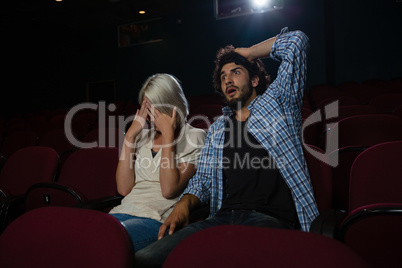 Couple with shocked expression looking at the movie