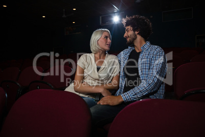 Couple looking at each other while sitting in the theatre