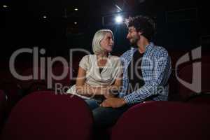 Couple looking at each other while sitting in the theatre
