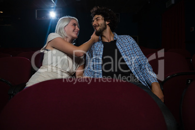 Couple looking at each other while sitting in the theatre