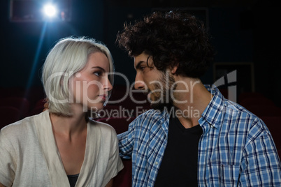 Couple looking at each other while sitting in the theatre