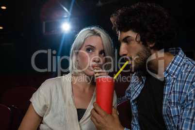 Couple having drinks while watching movie