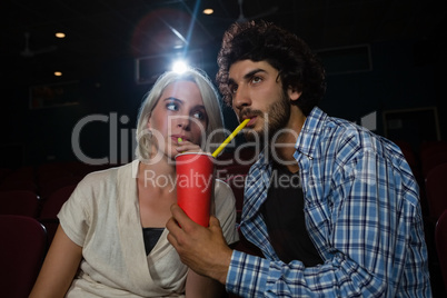 Couple having drinks while watching movie