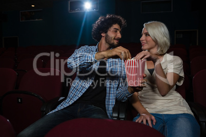 Couple looking at each other while sitting in the theatre