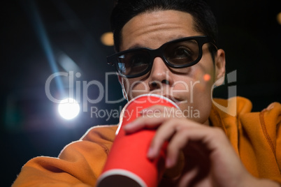 Man drinking cold drinks while watching movie