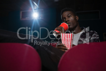 Man having cold drinks while watching movie