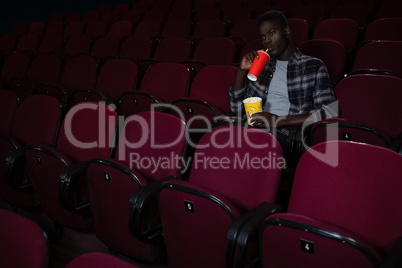 Man having cold drink while watching movie