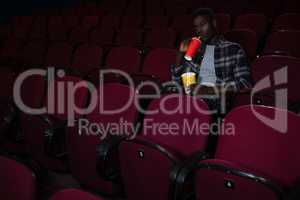 Man having cold drink while watching movie