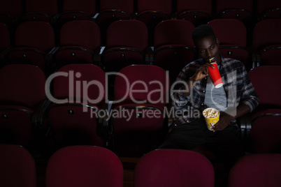 Man having cold drink while watching movie