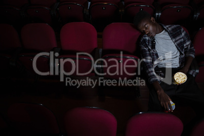 Man with popcorn sleeping in theatre