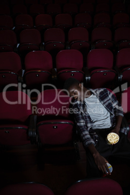 Man with popcorn sleeping in theatre