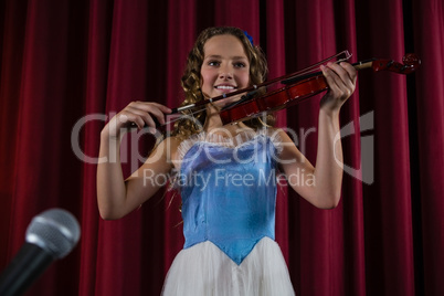Female artist playing violin on stage