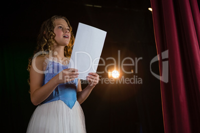 Female artist reading her scripts on stage