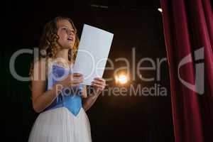 Female artist reading her scripts on stage