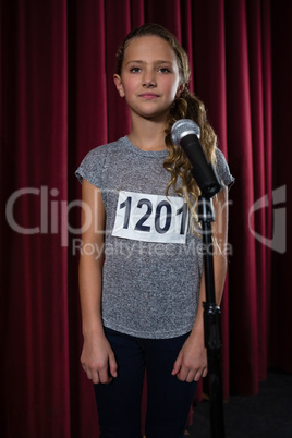 Girl standing front of microphone on stage