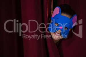 Ballet dancer peeking through a stage curtain