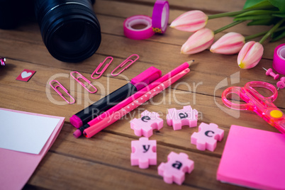 Close up of office supplies with camera and artificial tulip flowers