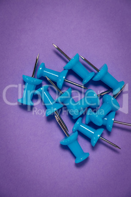 Overhead view of blue paper pins on paper