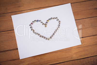 High angle view of paper pins arranged in heart shape on paper