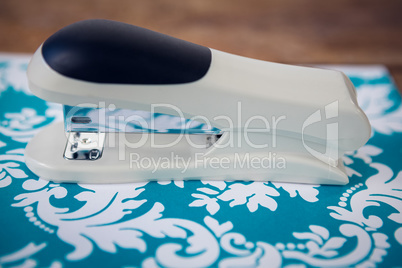 Close up of stapler on blue patterned paper