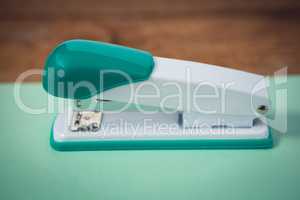 Close up of stapler on turquoise paper
