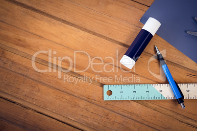 Overhead view of glue stick and pencil with ruler