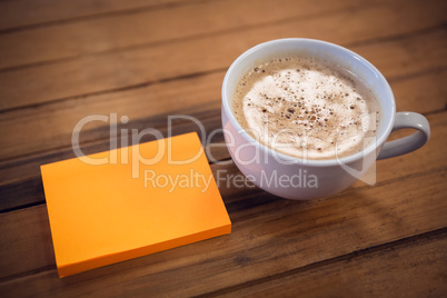 High agnle view of adhesive notes by coffee cup