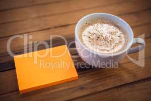High agnle view of adhesive notes by coffee cup