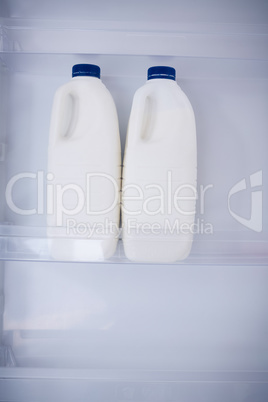 Close up white milk bottles in refrigerator