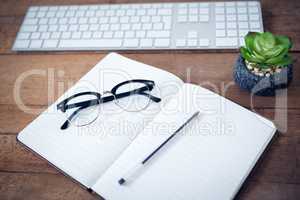 High angle view of diary with pen and eyeglasses by keyboard