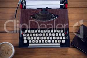 Close up of typewriter by coffee cup and book