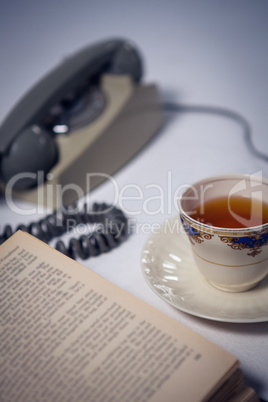 Close up of book with tea and telephone