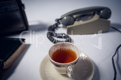 High angle view of tea by telephone with radio and book
