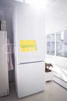 Drawing on yellow paper stuck to refrigerator by window