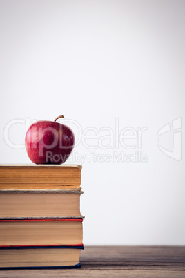 Close up of apple on books at table
