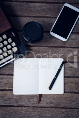 Directly above shot of typewriter by disposable cup and book