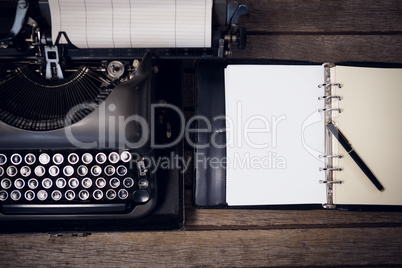 Typewriter by fountain pen on open diary