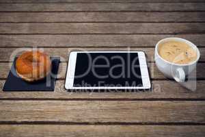 HIgh angle view of digital tablet with coffee cup donut