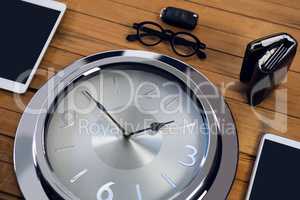 High angle view of wall clock with digital tablet and smart phone
