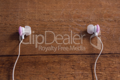 Pink earphones on wooden table