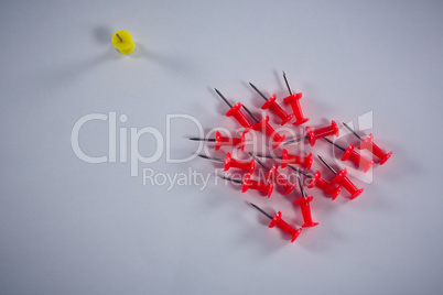Yellow and red push pins on white background