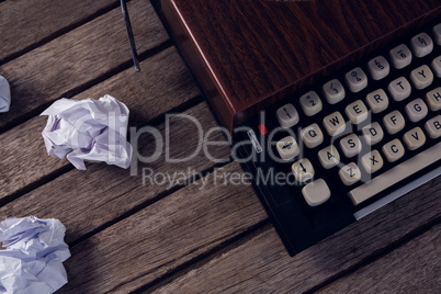 Vintage typewriter and crumbled paper on wooden table