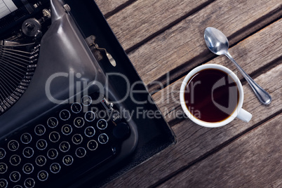 Vintage typewriter and cup of black coffee